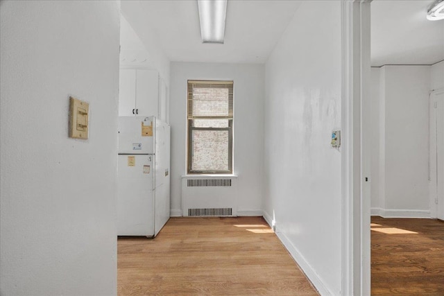 98-120 Queens Blvd Unit 5G, Rego Park, NY 11374 - hallway featuring radiator, light wood finished floors, and baseboards