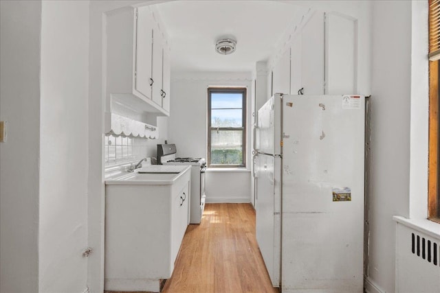 98-120 Queens Blvd Unit 5G, Rego Park, NY 11374 - kitchen featuring white appliances, light wood-style floors, white cabinetry, light countertops, and radiator