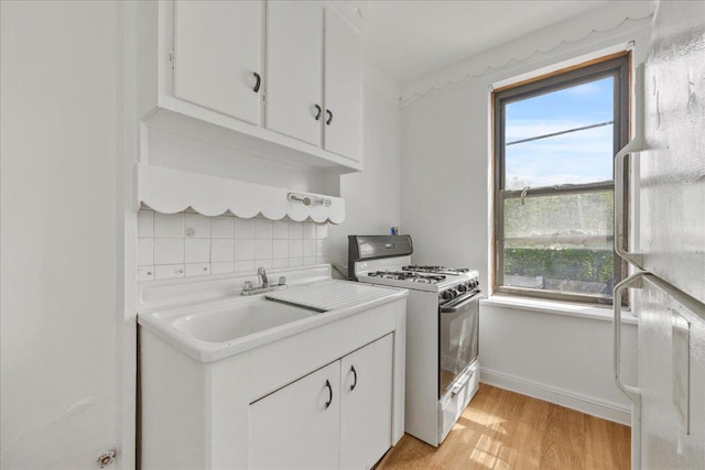 98-120 Queens Blvd Unit 5G, Rego Park, NY 11374 - kitchen with gas range gas stove, tasteful backsplash, white cabinets, and a sink