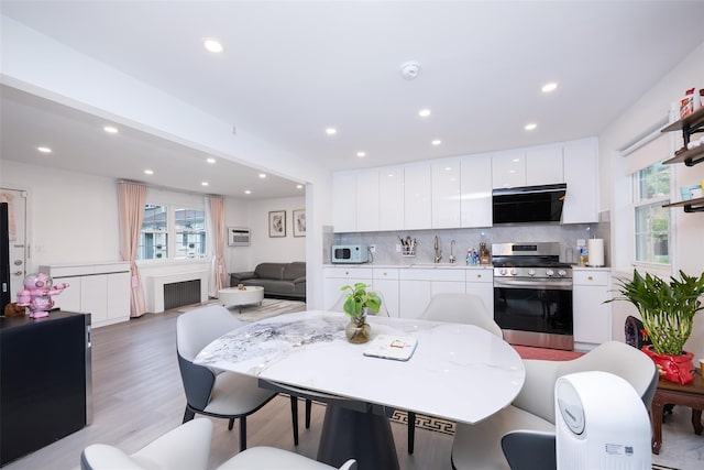 223-36 65th Ave Unit 2A, Bayside, NY 11364 - dining space with recessed lighting, plenty of natural light, light wood-style flooring, radiator heating unit, and a fireplace