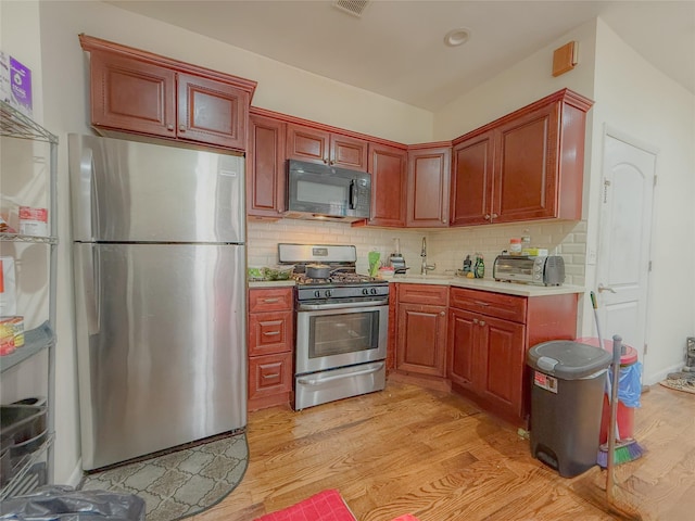 412 Newport St, Brooklyn, NY 11207 - kitchen with appliances with stainless steel finishes, light countertops, light wood-style floors, and decorative backsplash