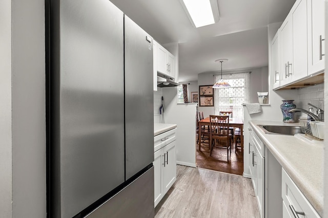 315 W 232nd St Unit 3C, Bronx, NY 10463 - kitchen featuring freestanding refrigerator, a sink, white cabinetry, light wood-style floors, and light countertops