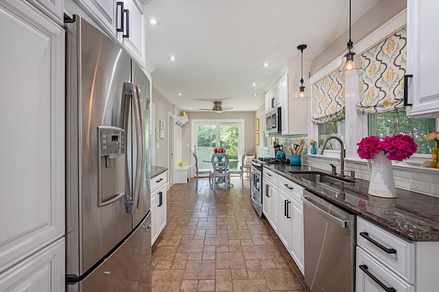 344 N Forest Ave, Rockville Centre, NY 11570 - kitchen with appliances with stainless steel finishes, stone tile flooring, a sink, decorative backsplash, and white cabinetry