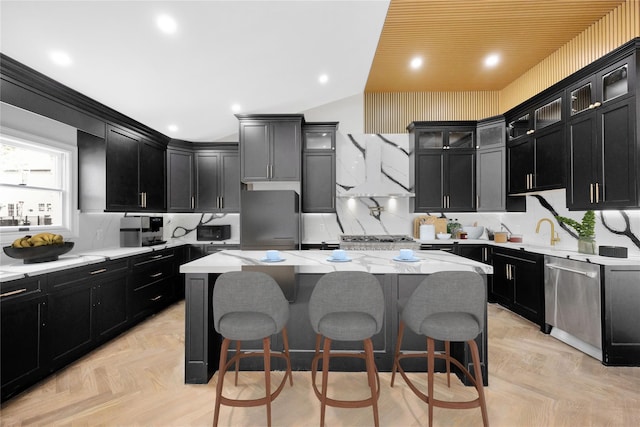 23 Vinton St, Long Beach, NY 11561 - kitchen featuring dark cabinets, a kitchen island, appliances with stainless steel finishes, and vaulted ceiling