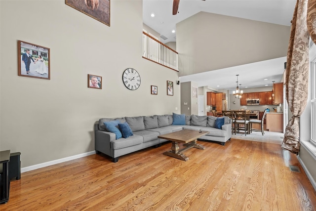 22 Restorative Ln, Middletown, NY 10940 - living area featuring ceiling fan, light wood-style flooring, a high ceiling, baseboards, and a chandelier