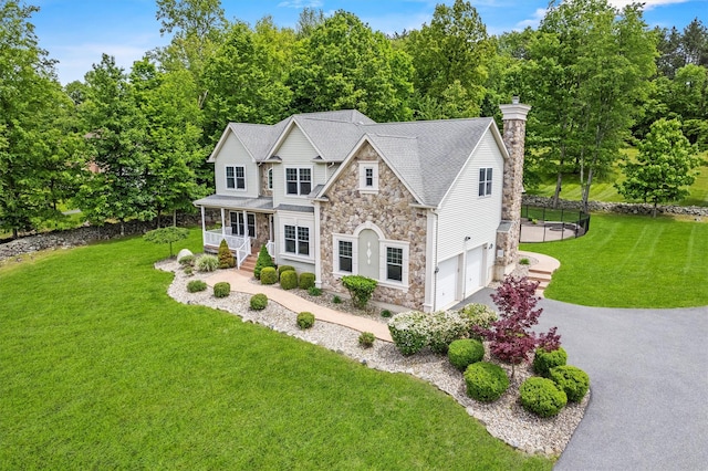 22 Restorative Ln, Middletown, NY 10940 - view of front of home featuring stone siding, an attached garage, covered porch, driveway, and a front lawn