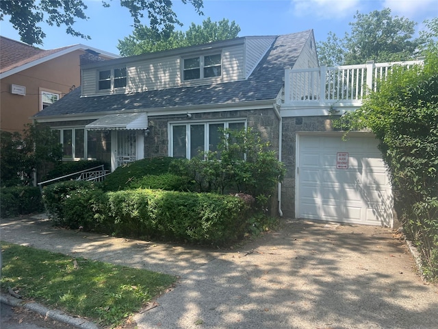 2449 Young Ave, Bronx, NY 10469 - view of front of house featuring stone siding, a balcony, and concrete driveway
