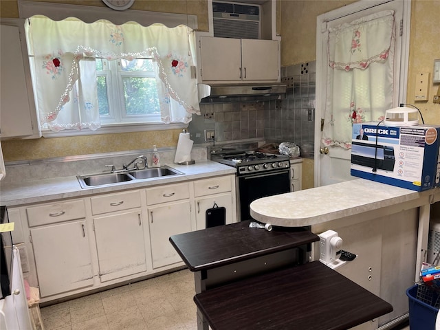 2449 Young Ave, Bronx, NY 10469 - kitchen featuring gas range, under cabinet range hood, light countertops, white cabinets, and tasteful backsplash