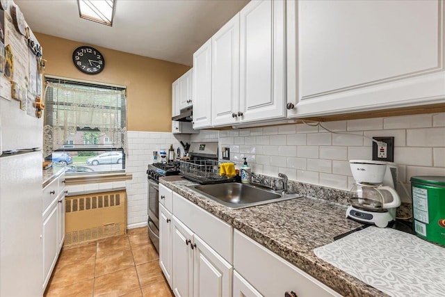 196-66 67th Ave Unit 1Fl, Fresh Meadows, NY 11365 - kitchen with gas stove, a sink, under cabinet range hood, freestanding refrigerator, and white cabinetry