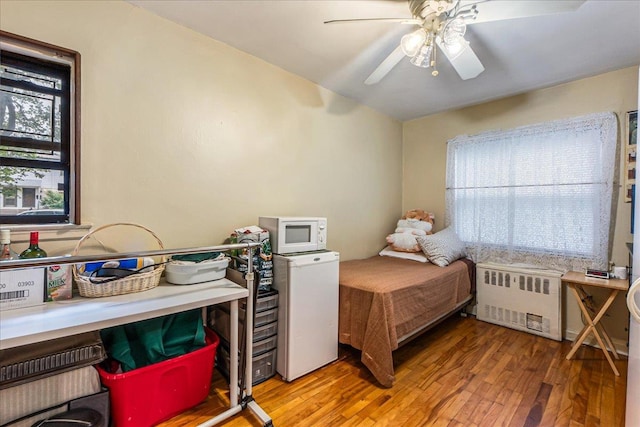 196-66 67th Ave Unit 1Fl, Fresh Meadows, NY 11365 - bedroom with radiator heating unit, hardwood / wood-style flooring, fridge, ceiling fan, and lofted ceiling