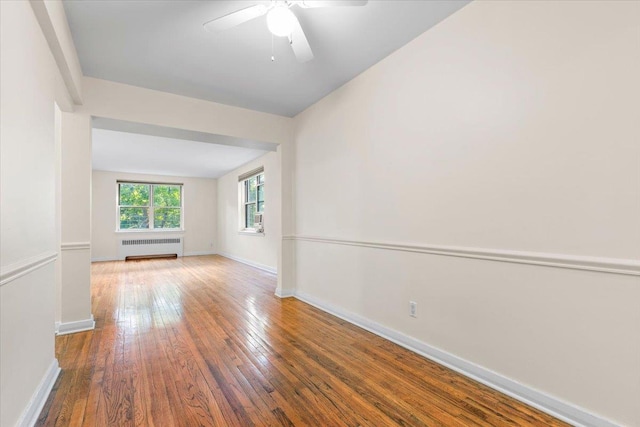 280 Collins Ave Unit 6J, Mount Vernon, NY 10552 - empty room with radiator, wood-type flooring, a ceiling fan, and baseboards