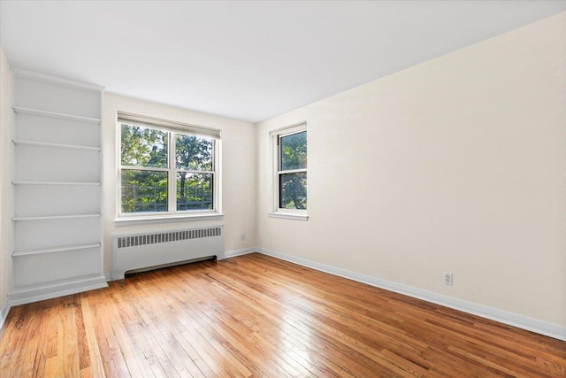 280 Collins Ave Unit 6J, Mount Vernon, NY 10552 - spare room featuring radiator, wood-type flooring, and baseboards