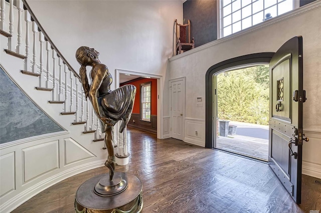 9 Stream Ct, Great Neck, NY 11024 - foyer with a decorative wall, wainscoting, arched walkways, wood finished floors, and stairway