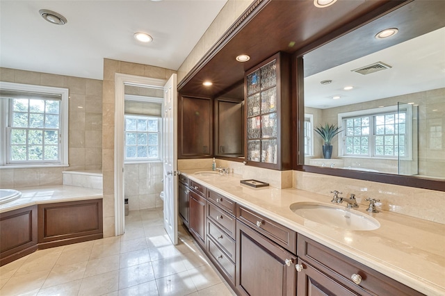 9 Stream Ct, Great Neck, NY 11024 - bathroom featuring tile walls, tile patterned floors, a garden tub, double vanity, and toilet
