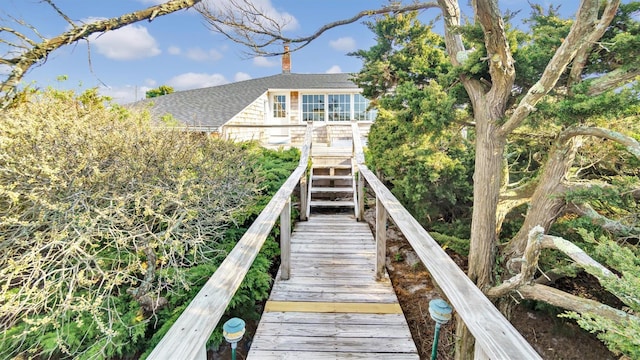 234 Dune Rd, Quogue, NY 11959 - back of property featuring a shingled roof, a chimney, and stairway