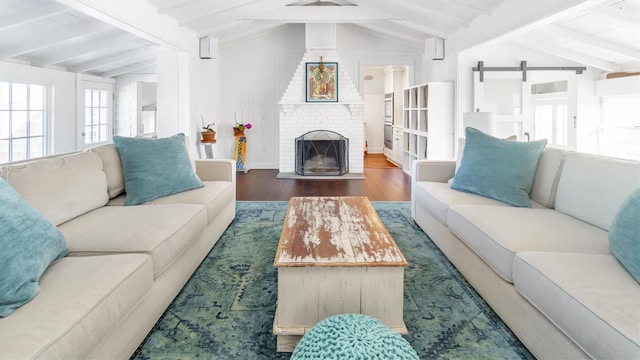234 Dune Rd, Quogue, NY 11959 - living area featuring wood finished floors, a barn door, and a brick fireplace