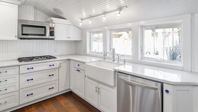 234 Dune Rd, Quogue, NY 11959 - kitchen featuring stainless steel appliances, a sink, white cabinetry, light countertops, and dark wood-style flooring