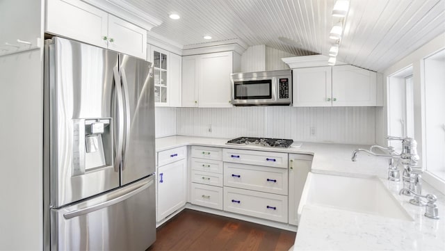 234 Dune Rd, Quogue, NY 11959 - kitchen with stainless steel appliances, a sink, white cabinetry, glass insert cabinets, and dark wood-type flooring