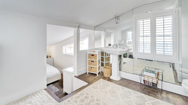 234 Dune Rd, Quogue, NY 11959 - bedroom with multiple windows, wood finished floors, vaulted ceiling, and baseboards