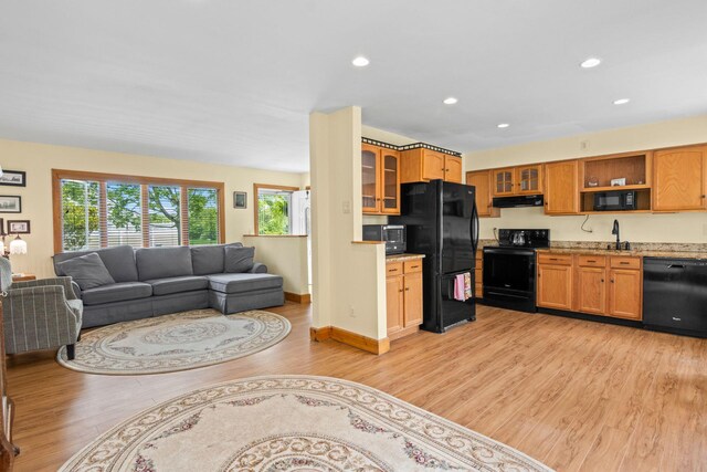 1 Chuck Ln, Selden, NY 11784 - kitchen featuring black appliances, under cabinet range hood, light wood-style floors, open floor plan, and glass insert cabinets
