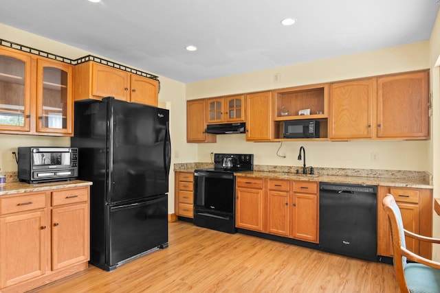 1 Chuck Ln, Selden, NY 11784 - kitchen with black appliances, under cabinet range hood, light wood-type flooring, glass insert cabinets, and light stone countertops