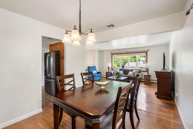 67 Keats Dr, New Windsor, NY 12553 - dining area featuring a chandelier, a baseboard heating unit, light wood-style flooring, and baseboards