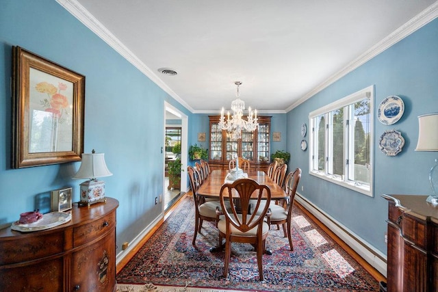 129 Colony Ln, Syosset, NY 11791 - dining space with wood finished floors, a baseboard heating unit, healthy amount of natural light, a chandelier, and crown molding