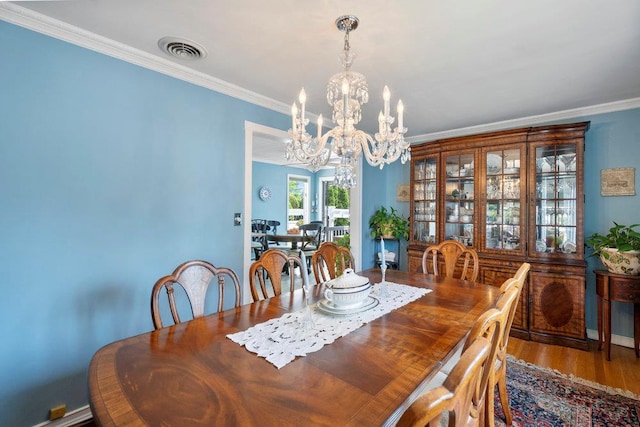 129 Colony Ln, Syosset, NY 11791 - dining space with a chandelier, crown molding, and wood finished floors