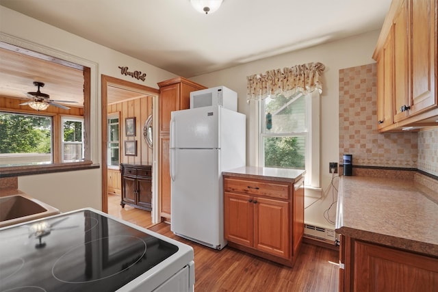 34 Argyle St, Lake Peekskill, NY 10537 - kitchen featuring white appliances, baseboard heating, backsplash, light wood-style floors, and ceiling fan