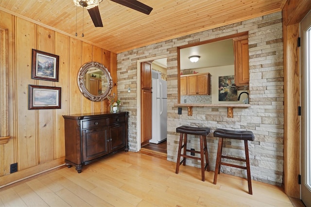 34 Argyle St, Lake Peekskill, NY 10537 - bar featuring wooden ceiling, freestanding refrigerator, ceiling fan, light wood-style floors, and wooden walls