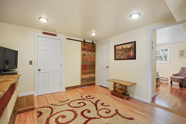34 Argyle St, Lake Peekskill, NY 10537 - entrance foyer with a barn door, wood finished floors, a baseboard heating unit, baseboards, and recessed lighting
