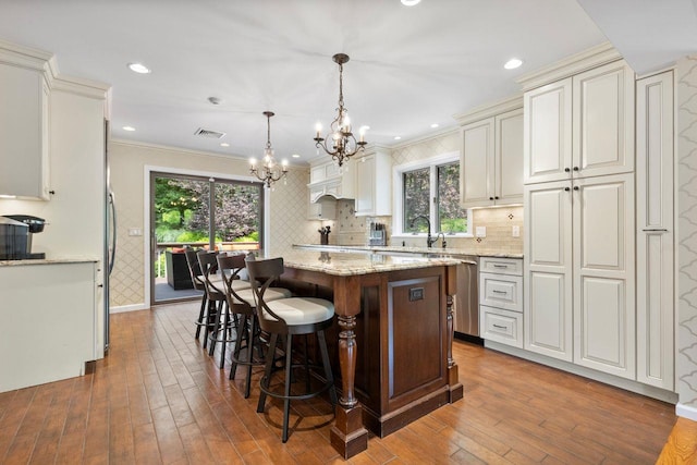 226 Briarwood Dr, Somers, NY 10589 - kitchen with a chandelier, a center island, dark wood-style floors, light stone counters, and crown molding