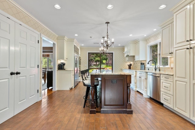 226 Briarwood Dr, Somers, NY 10589 - kitchen featuring stainless steel dishwasher, a chandelier, a center island, healthy amount of natural light, and ornamental molding