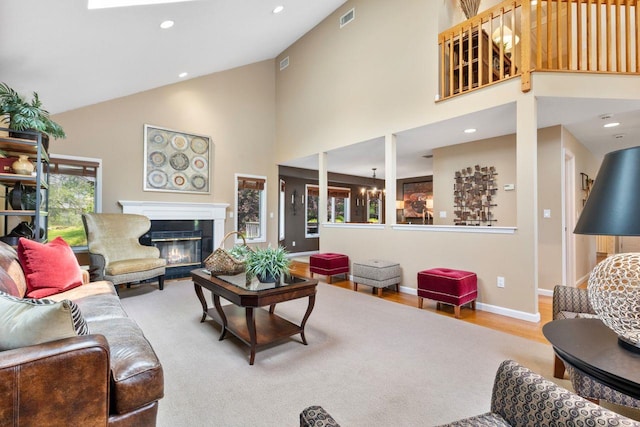 226 Briarwood Dr, Somers, NY 10589 - living area featuring high vaulted ceiling, a glass covered fireplace, recessed lighting, a chandelier, and wood finished floors