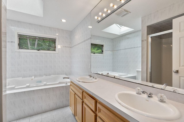 226 Briarwood Dr, Somers, NY 10589 - bathroom featuring a skylight, tile patterned floors, a garden tub, tile walls, and double vanity