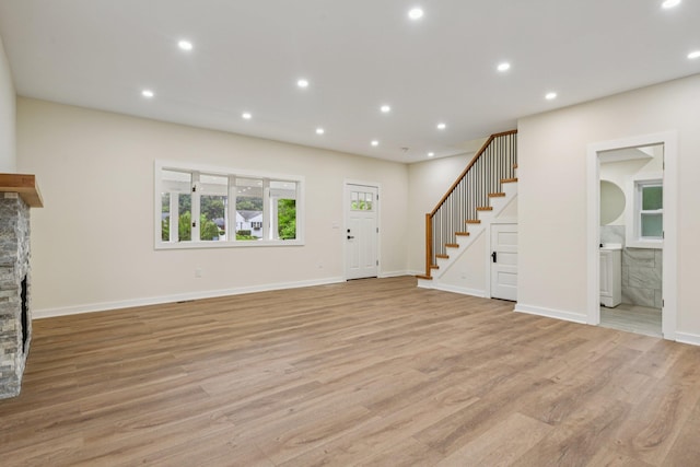 1293 Pulaski Rd, East Northport, NY 11731 - unfurnished living room featuring stairs, a fireplace, light wood-style floors, recessed lighting, and baseboards