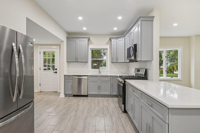 1293 Pulaski Rd, East Northport, NY 11731 - kitchen with stainless steel appliances, gray cabinets, plenty of natural light, a peninsula, and recessed lighting