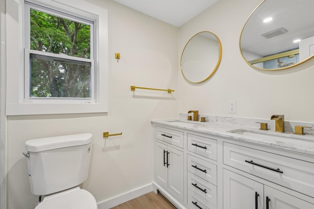 1293 Pulaski Rd, East Northport, NY 11731 - bathroom with double vanity, wood finished floors, baseboards, and toilet