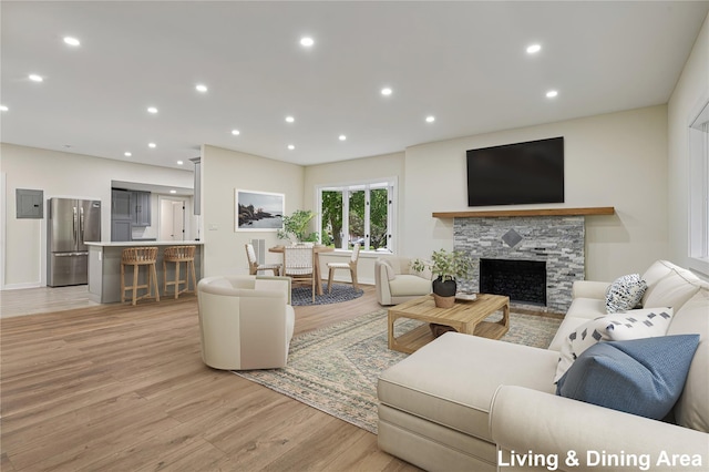 1293 Pulaski Rd, East Northport, NY 11731 - living area featuring light wood-style floors, a stone fireplace, recessed lighting, and electric panel