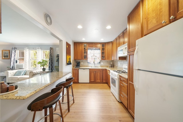 131-2 S Highland Ave Unit A3, Ossining, NY 10562 - kitchen with white appliances, a breakfast bar, healthy amount of natural light, recessed lighting, and glass insert cabinets