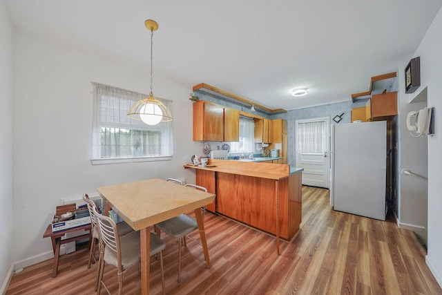3 Shelter Hill Rd, Plainview, NY 11803 - kitchen with freestanding refrigerator, a peninsula, brown cabinets, and plenty of natural light