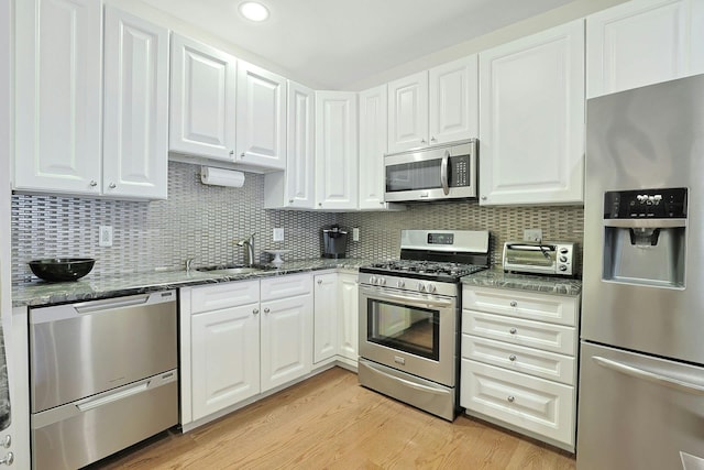 24 N De Baun Ave Unit 308, Suffern, NY 10901 - kitchen with stainless steel appliances, a sink, white cabinets, dark stone countertops, and tasteful backsplash
