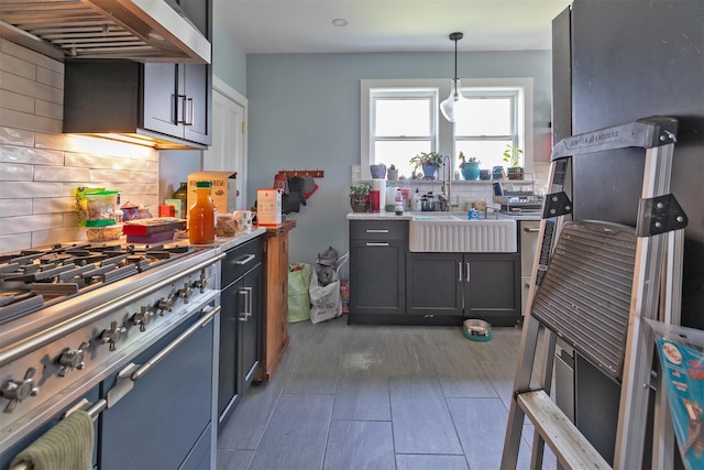 184 Highland Ave, Middletown, NY 10940 - kitchen featuring range, wall chimney range hood, backsplash, decorative light fixtures, and light countertops