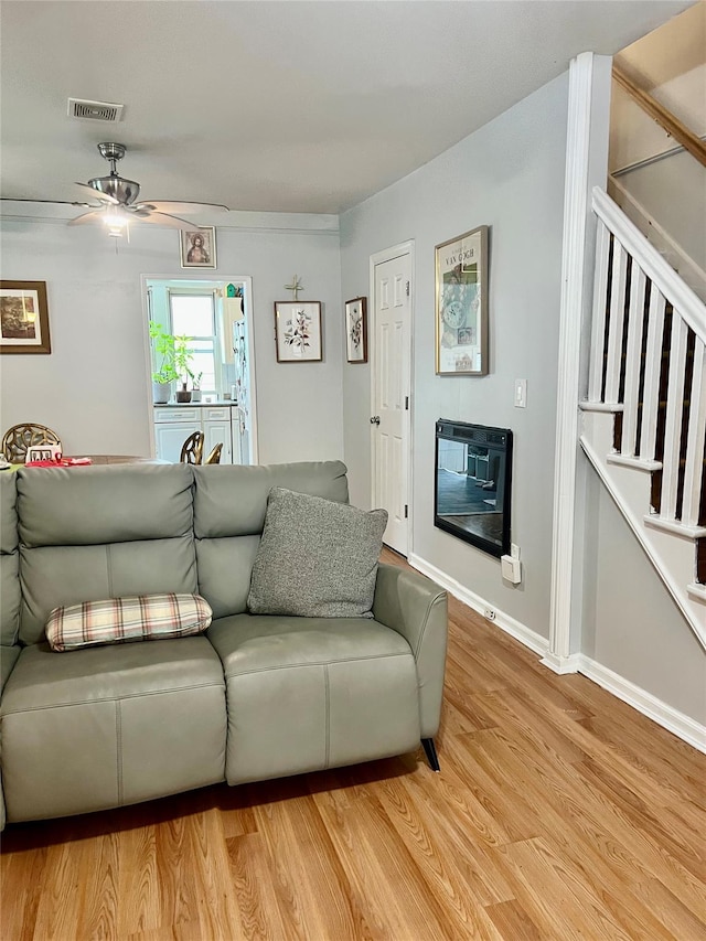 22-26 74th St, East Elmhurst, NY 11370 - living room with a ceiling fan, light wood-style flooring, and stairs