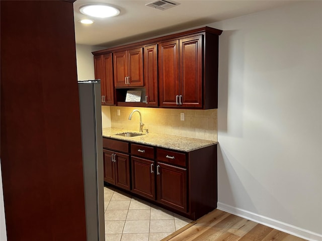 305C Torquay Court, Ridge, NY 11961 - kitchen with freestanding refrigerator, backsplash, light stone counters, and light wood finished floors