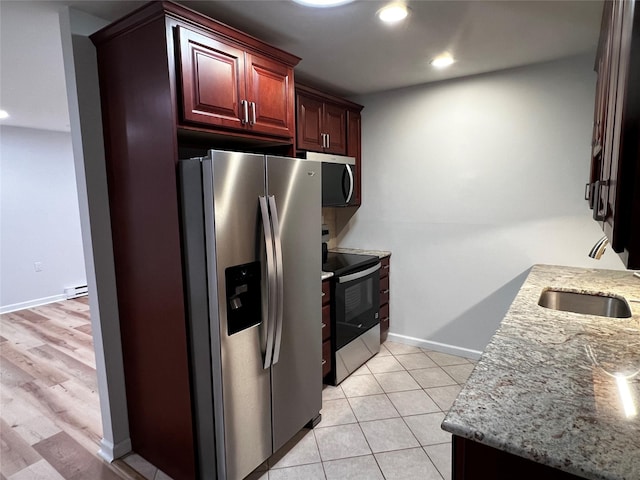 305C Torquay Court, Ridge, NY 11961 - kitchen featuring appliances with stainless steel finishes, recessed lighting, light stone counters, reddish brown cabinets, and light tile patterned floors