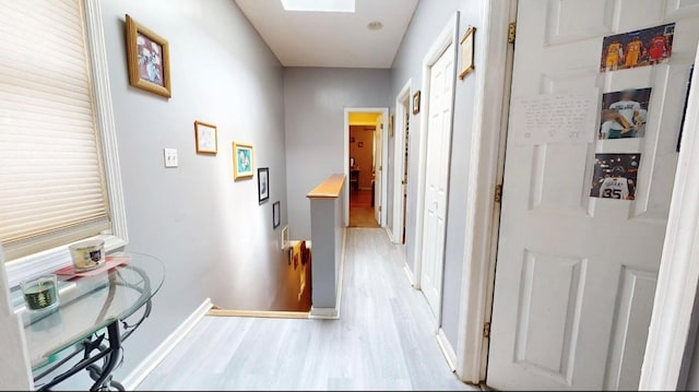 2547 Laconia Ave, Bronx, NY 10469 - hallway featuring light wood-style flooring, baseboards, an upstairs landing, and a skylight
