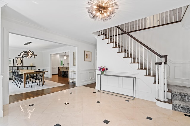 1508 Laurel Hollow Rd, Laurel Hollow, NY 11791 - staircase with a chandelier, a decorative wall, ornamental molding, tile patterned flooring, and a wainscoted wall