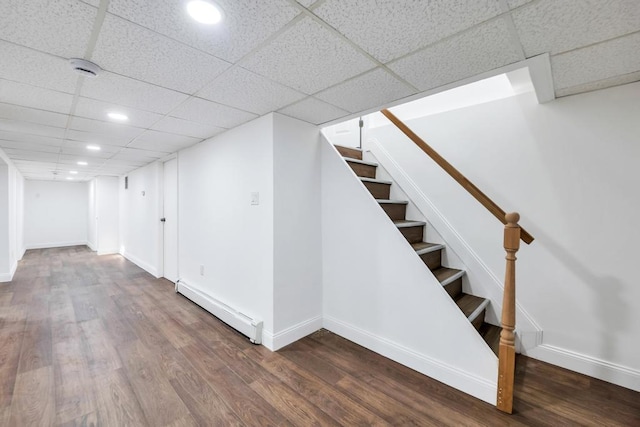 7 Argyle Dr, Shirley, NY 11967 - finished below grade area featuring baseboard heating, wood finished floors, stairs, a paneled ceiling, and recessed lighting