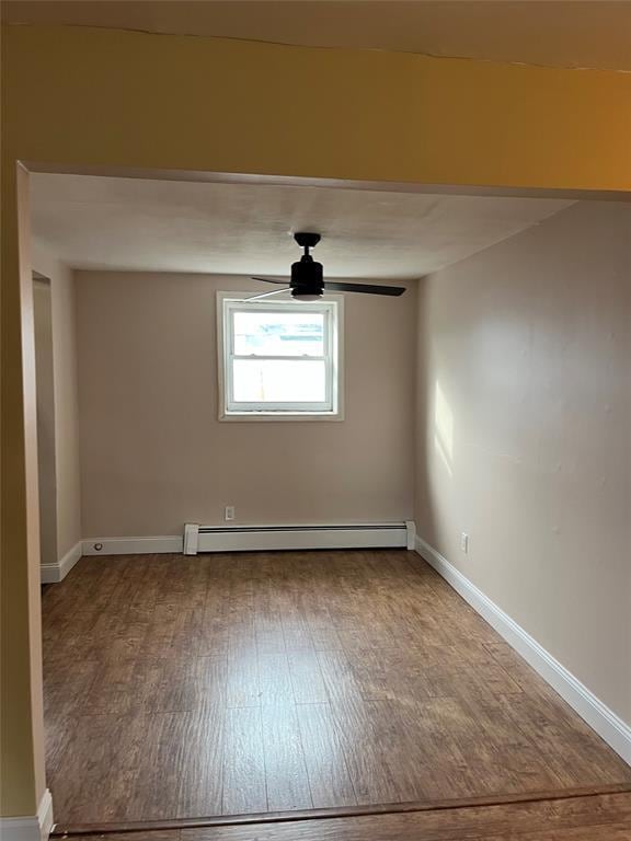 1548 Rte 9 Unit 1B, Wappingers Falls, NY 12590 - empty room with wood finished floors, a baseboard radiator, a ceiling fan, and baseboards